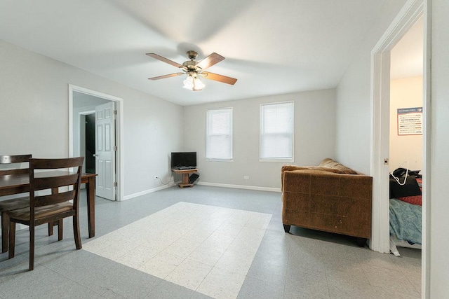 interior space with tile patterned floors, a ceiling fan, and baseboards