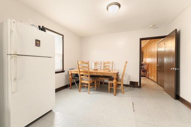 dining area featuring light floors and baseboards