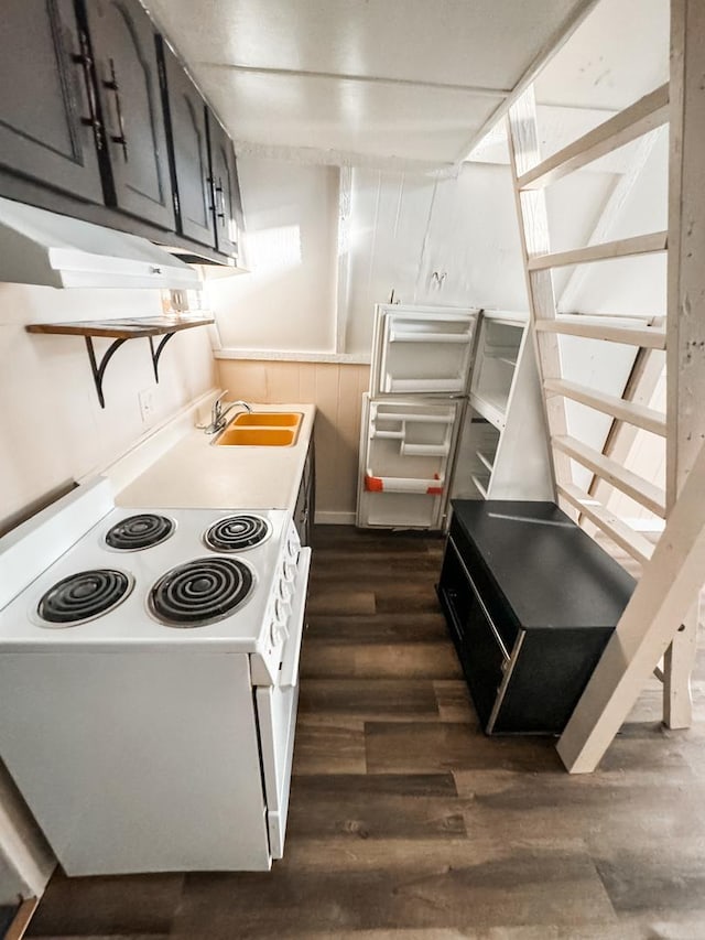 kitchen with dark wood finished floors, light countertops, a sink, and white range with electric stovetop