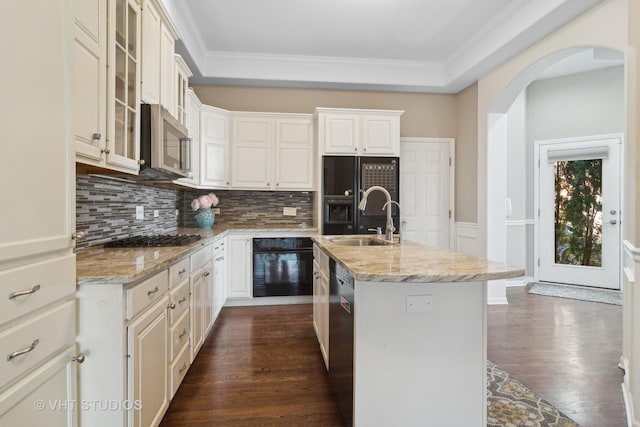 kitchen featuring light stone counters, ornamental molding, dark wood-type flooring, black appliances, and a sink