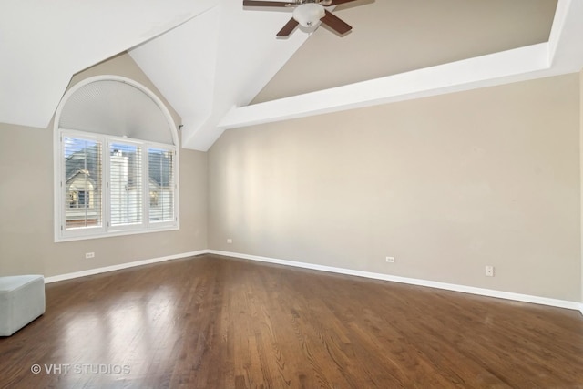 empty room featuring dark wood-style floors, lofted ceiling, ceiling fan, and baseboards