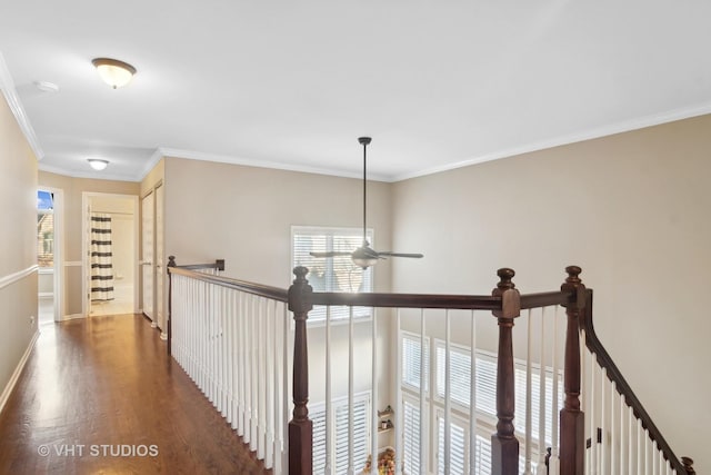 hallway with baseboards, ornamental molding, wood finished floors, and an upstairs landing