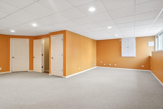 basement featuring light carpet, a drop ceiling, recessed lighting, and baseboards