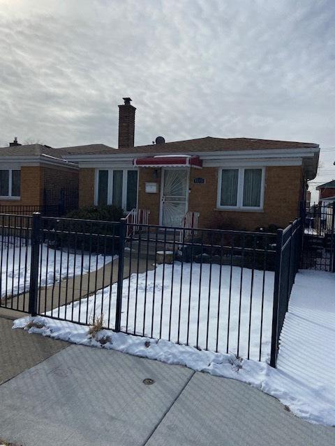 single story home with a fenced front yard, a chimney, and brick siding