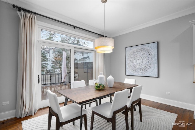 dining area featuring crown molding, baseboards, and dark wood-style flooring