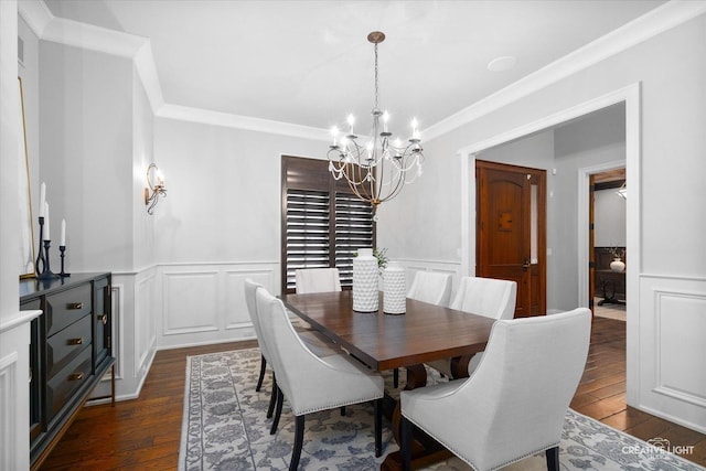 dining room with dark wood-type flooring, an inviting chandelier, crown molding, and a decorative wall