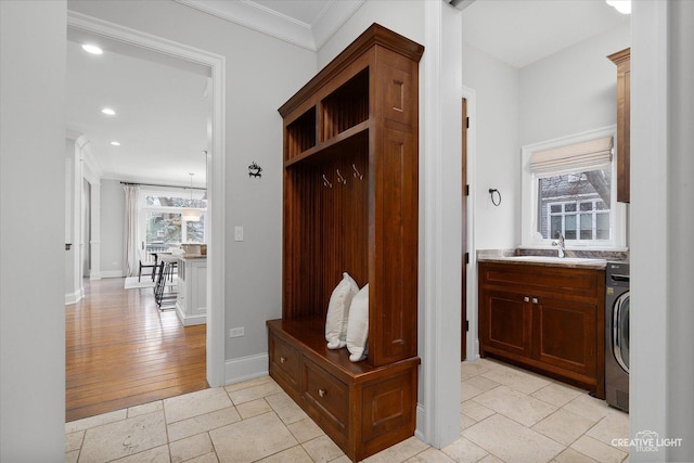 mudroom with baseboards, washer / dryer, recessed lighting, a sink, and crown molding