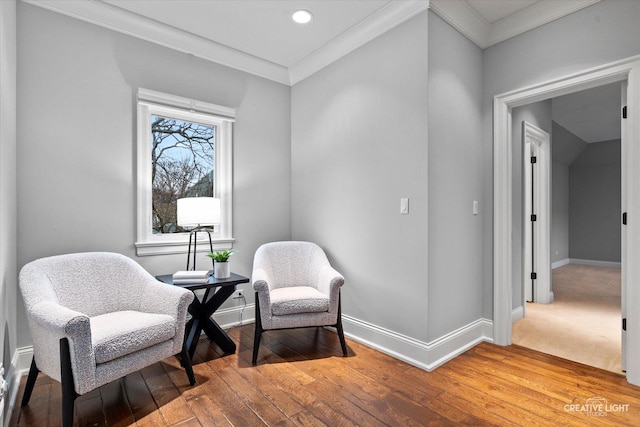 sitting room featuring light wood-type flooring, baseboards, and ornamental molding