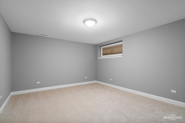 spare room with visible vents, light colored carpet, and baseboards