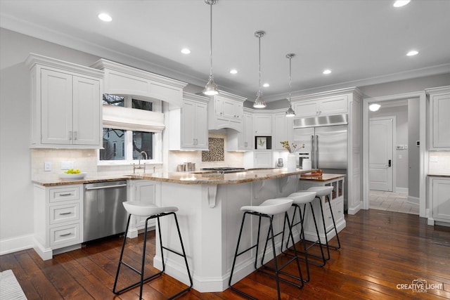 kitchen featuring a kitchen island, white cabinetry, a kitchen breakfast bar, and stainless steel appliances