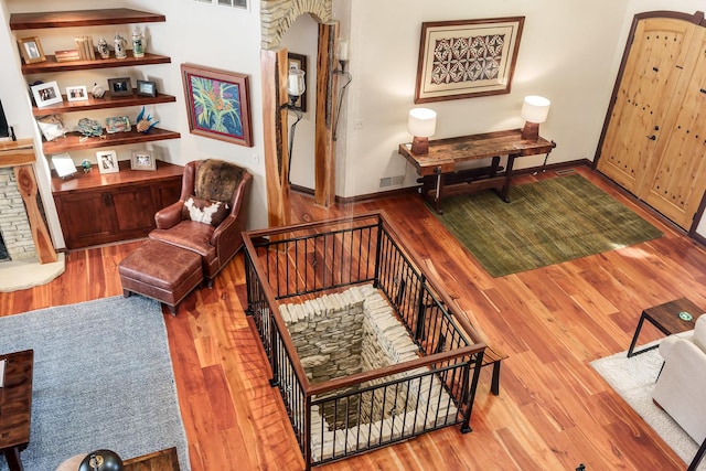 living area with visible vents, a fireplace, an upstairs landing, and wood finished floors