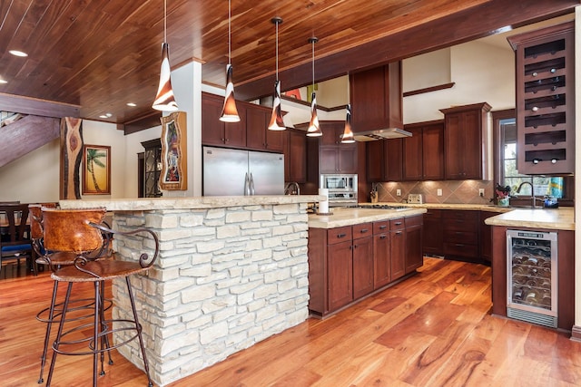 kitchen with decorative light fixtures, a breakfast bar area, stainless steel appliances, wooden ceiling, and beverage cooler