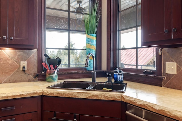 kitchen with reddish brown cabinets, decorative backsplash, dishwasher, light countertops, and a sink