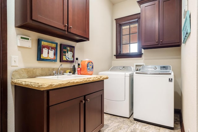 laundry area featuring cabinet space, a sink, and washer and clothes dryer