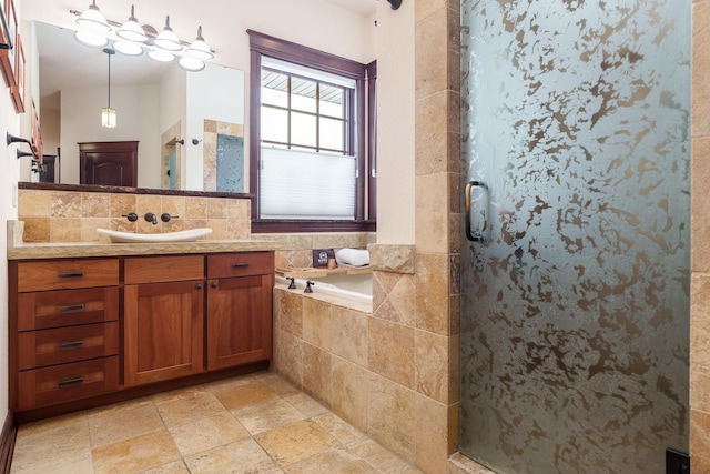 full bathroom with stone tile flooring, a shower stall, and vanity