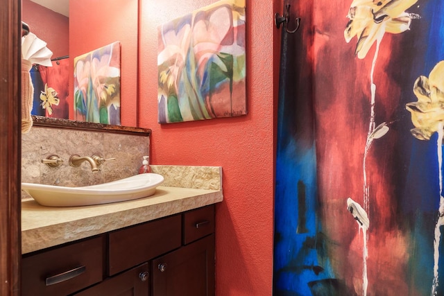 bathroom featuring a textured wall and vanity