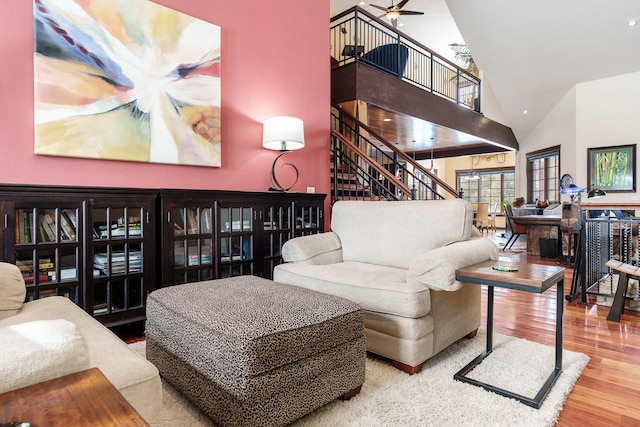 living area featuring ceiling fan, wood finished floors, stairs, high vaulted ceiling, and recessed lighting