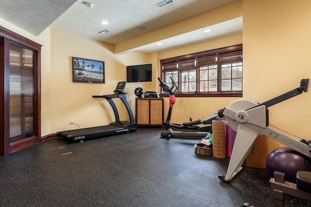 workout area featuring recessed lighting, visible vents, a textured ceiling, and baseboards