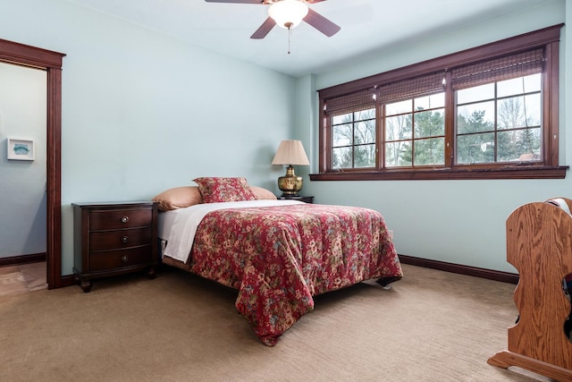 bedroom with light carpet, baseboards, and a ceiling fan