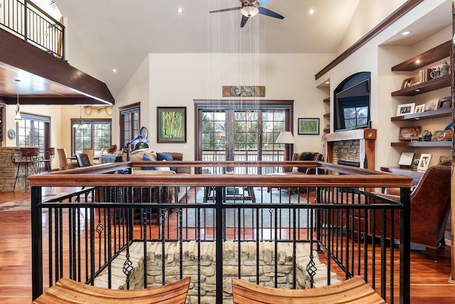 bar featuring a ceiling fan, wood finished floors, a fireplace, high vaulted ceiling, and recessed lighting