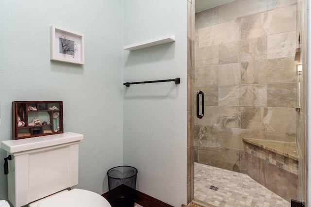 bathroom featuring toilet and a stall shower