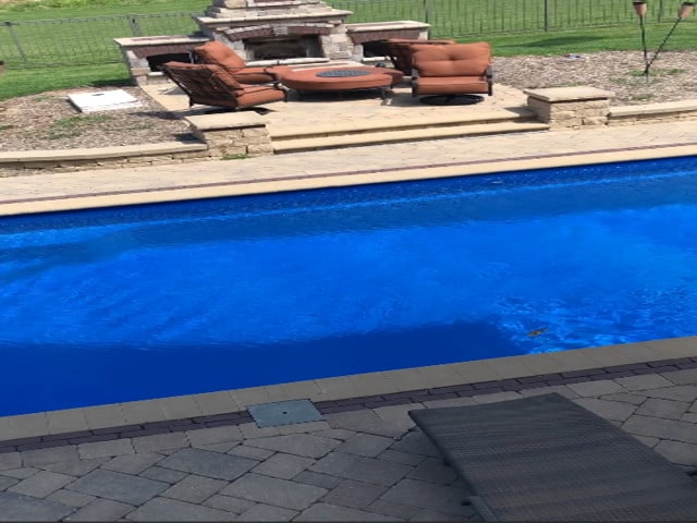 view of swimming pool featuring an outdoor fire pit, a patio area, and fence