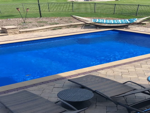 view of pool featuring fence and a lawn