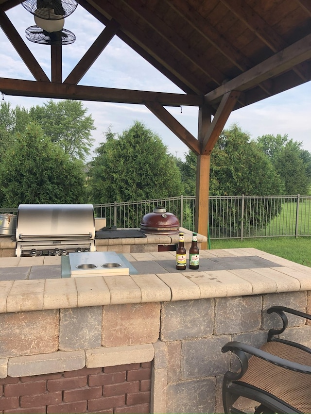 view of patio featuring fence, grilling area, and an outdoor kitchen