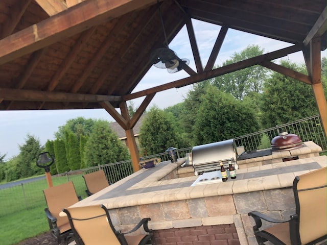 view of patio with exterior bar, a gazebo, and area for grilling