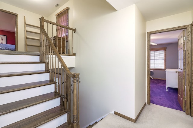 staircase with carpet flooring, visible vents, and baseboards