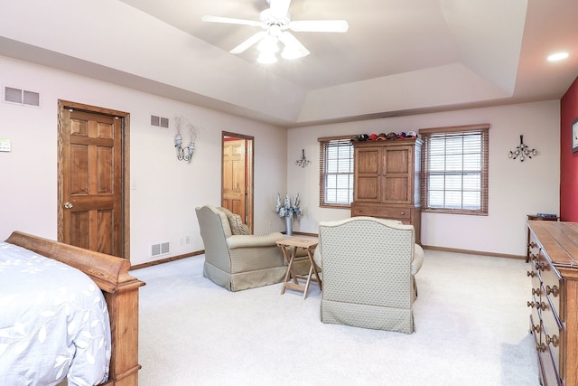 bedroom with a tray ceiling and visible vents