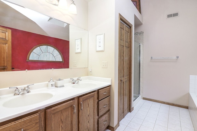 full bathroom with double vanity, a stall shower, visible vents, and a sink