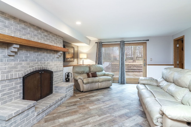 living area featuring light wood-style floors, recessed lighting, and a fireplace