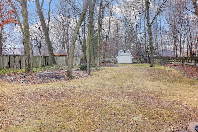 view of yard featuring a shed, fence, and an outbuilding