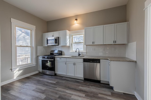 1503 Ottawa Ave, Ottawa, IL 61350 - kitchen featuring tasteful backsplash, light stone counters, appliances with stainless steel finishes, white cabinetry, and a sink