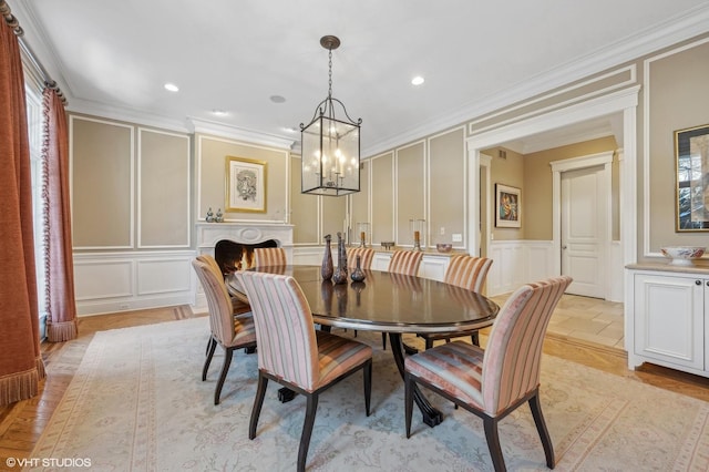 dining room with crown molding, recessed lighting, and a decorative wall