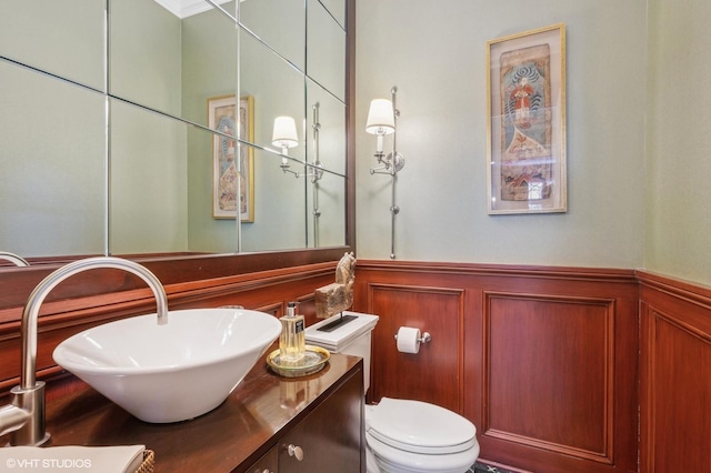 bathroom with toilet, wainscoting, and vanity