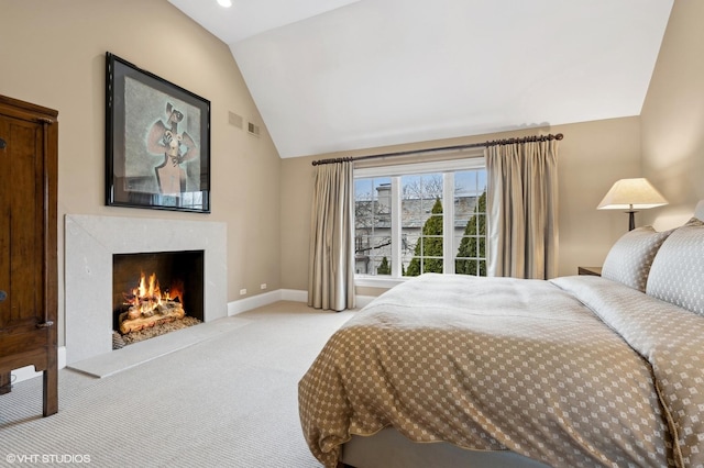 bedroom with light carpet, visible vents, baseboards, vaulted ceiling, and a fireplace