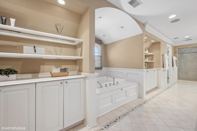 full bathroom featuring built in features, recessed lighting, a garden tub, and visible vents