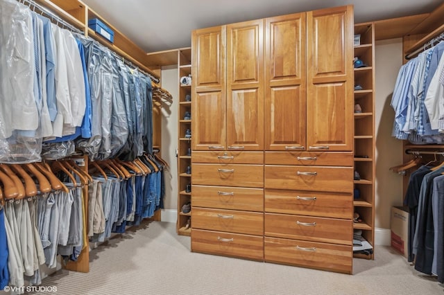 walk in closet featuring light colored carpet