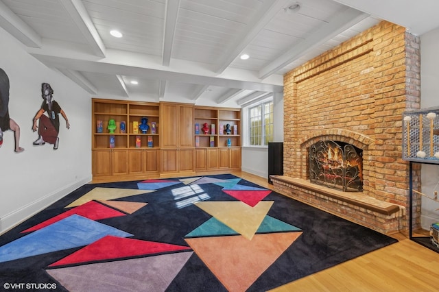 interior space featuring a fireplace, wood finished floors, and baseboards