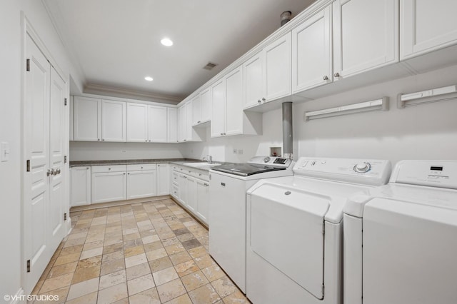 clothes washing area with recessed lighting, cabinet space, ornamental molding, washing machine and dryer, and a sink