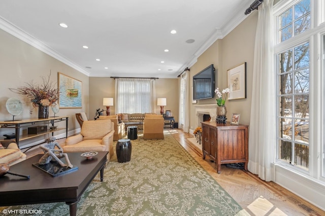 living room featuring a lit fireplace, crown molding, and recessed lighting