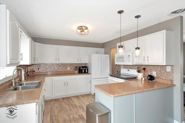 kitchen featuring white appliances, a sink, decorative light fixtures, and white cabinets