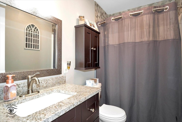 full bathroom featuring toilet, curtained shower, and vanity