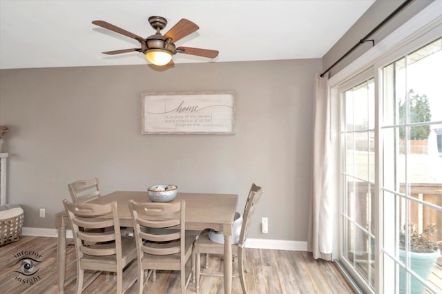 dining area featuring light wood finished floors, baseboards, and a ceiling fan