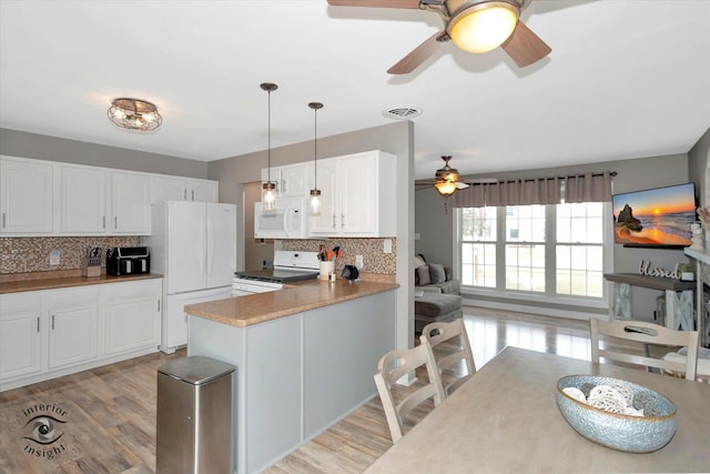 kitchen featuring white appliances, white cabinetry, and pendant lighting