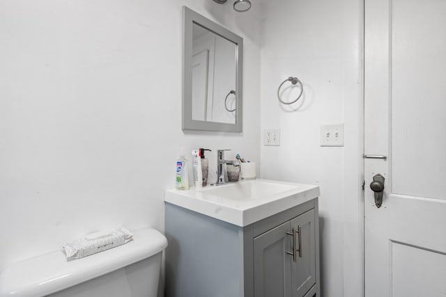 half bath featuring vanity and toilet