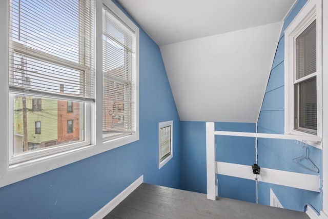 bonus room featuring lofted ceiling, baseboards, and wood finished floors
