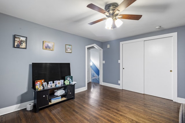 living room featuring dark wood-style floors, baseboards, and a ceiling fan